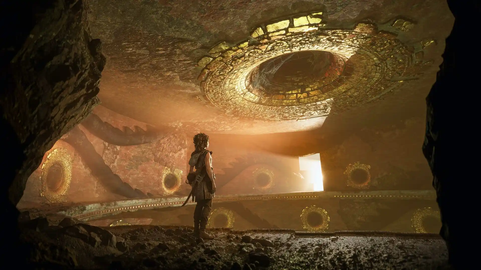 Sophia in a large hall with shafts of sunlight at the far end