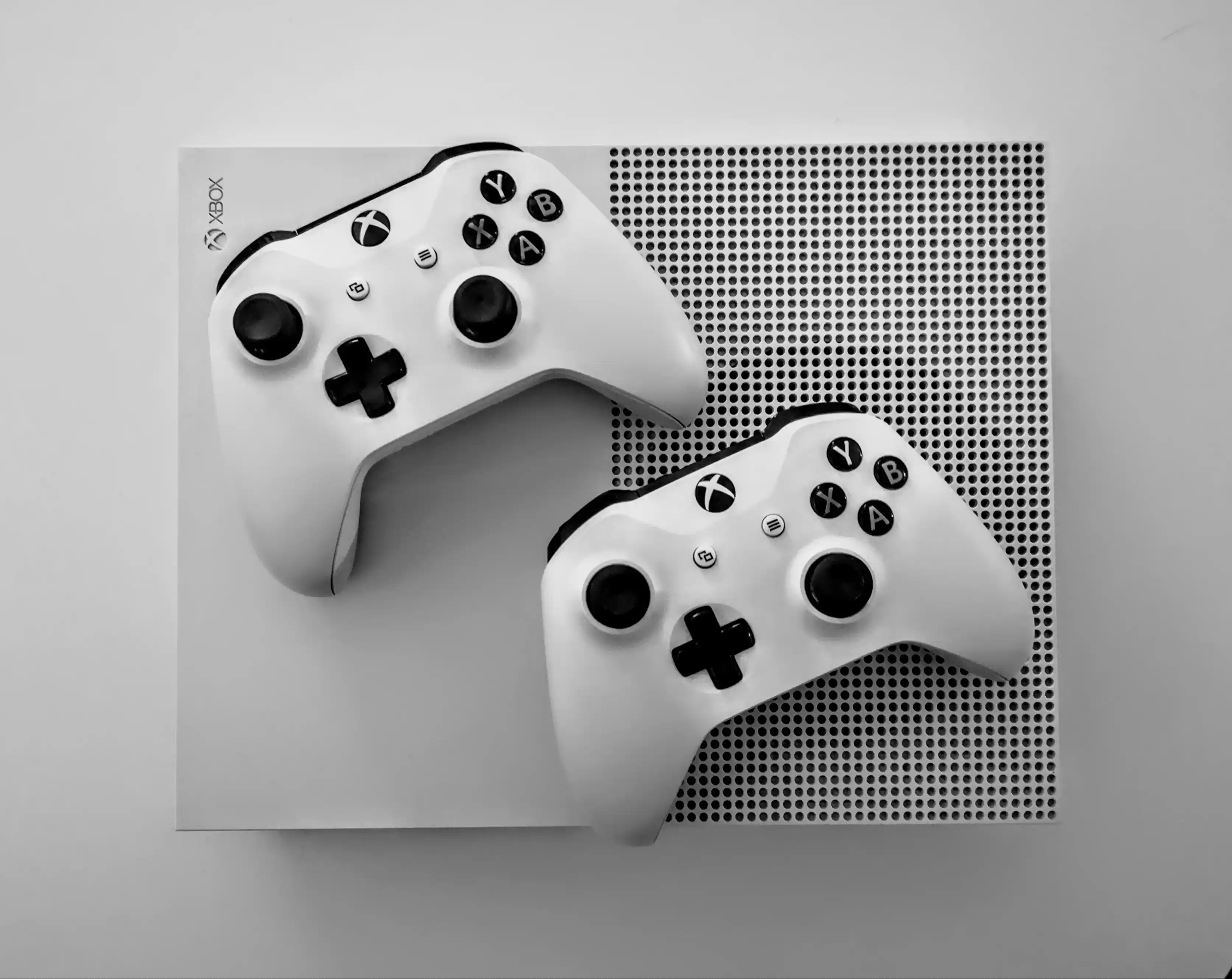 White Xbox console with two controllers on top