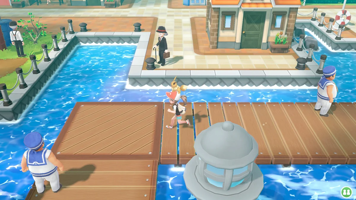 Protagonista con Eevee en el sombrero en un muelle del puerto en Pokémon Let's Go